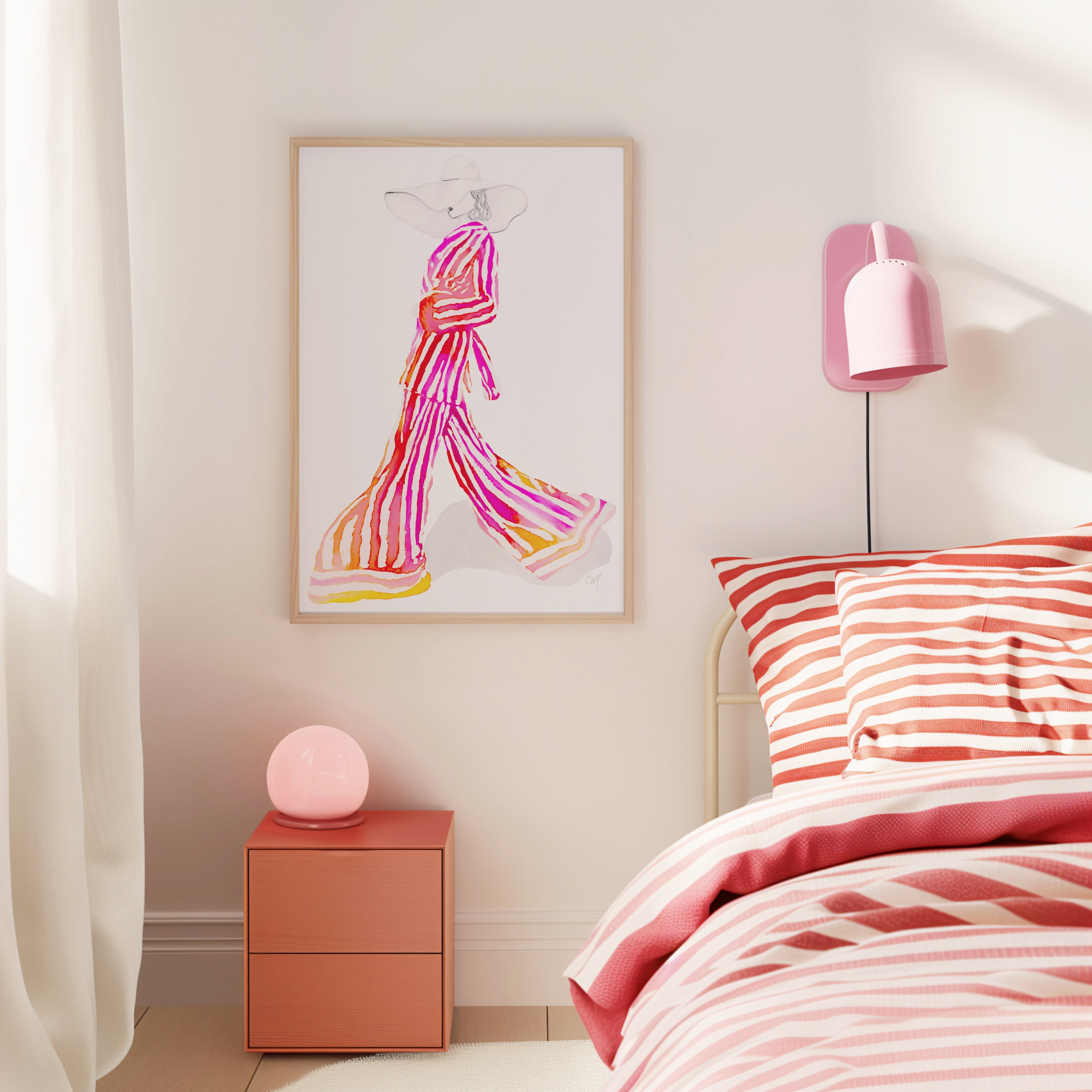 Gold framed fashion illustration art prints leaning against a pink wall.