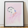 Framed artwork of a person in a pink outfit on a white wall.