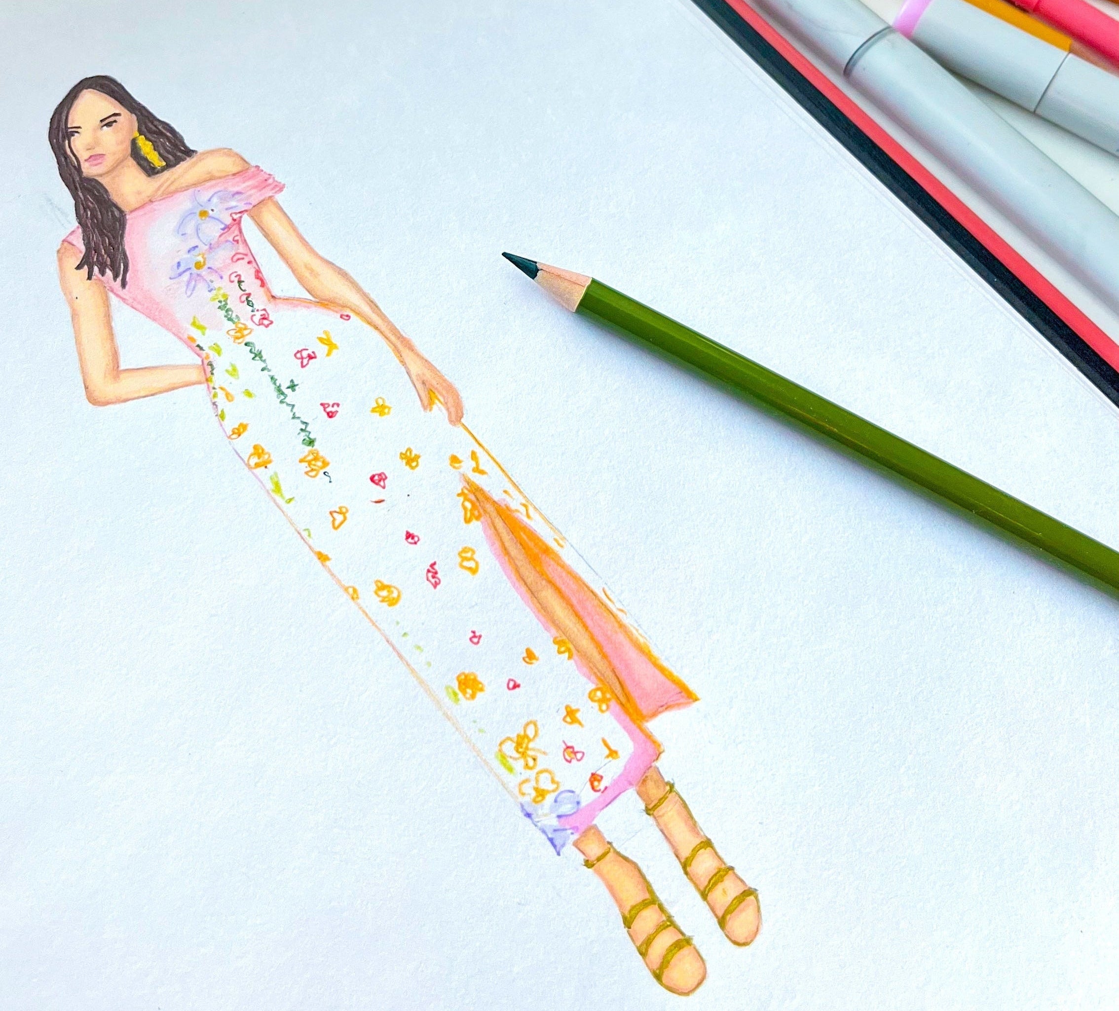 Artistic drawing of a woman in a dress on a white sheet of paper with colored pencils and markers.