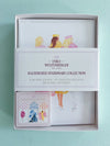 Emily Westenberger The Label Illustrated Stationery Collection in a white gift box, showing blank cards and lined envelopes with pastel watercolor illustrations on a light blue-green background.